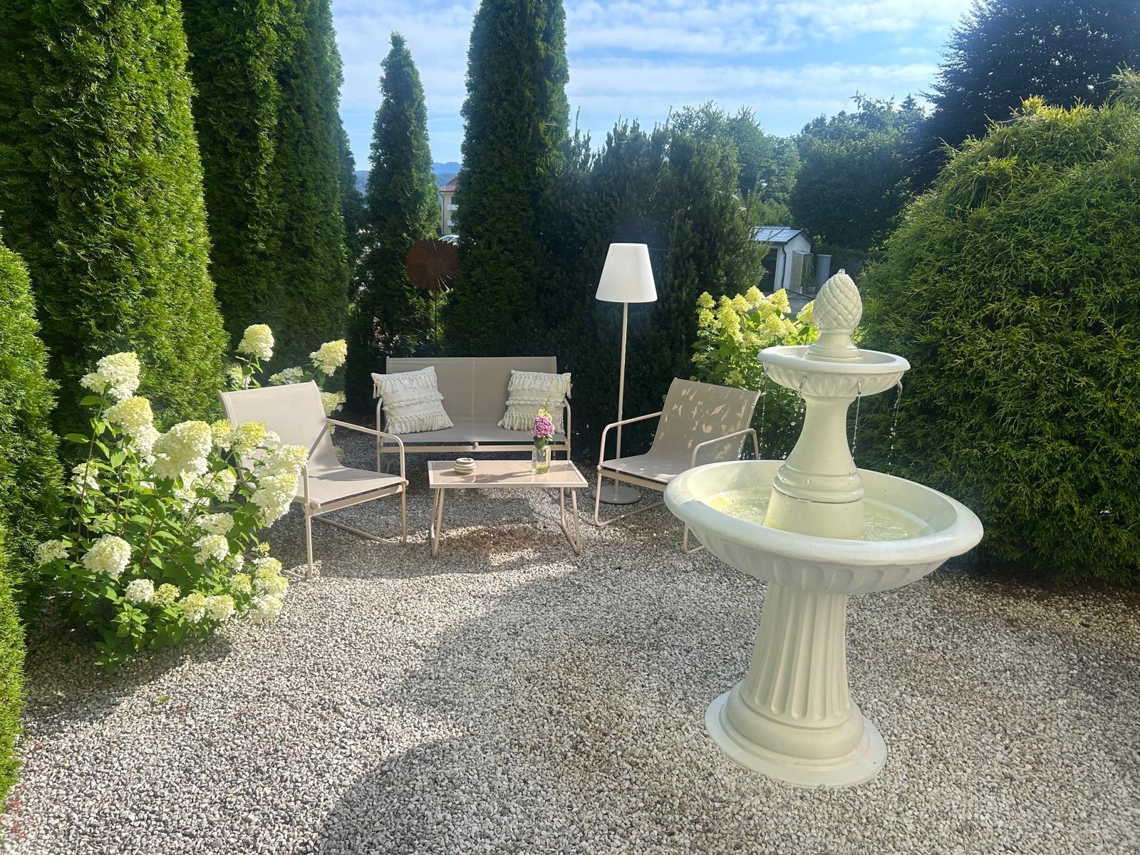 Gartenlounge mit Brunnen im Garten der Pension Wiegele in Velden
